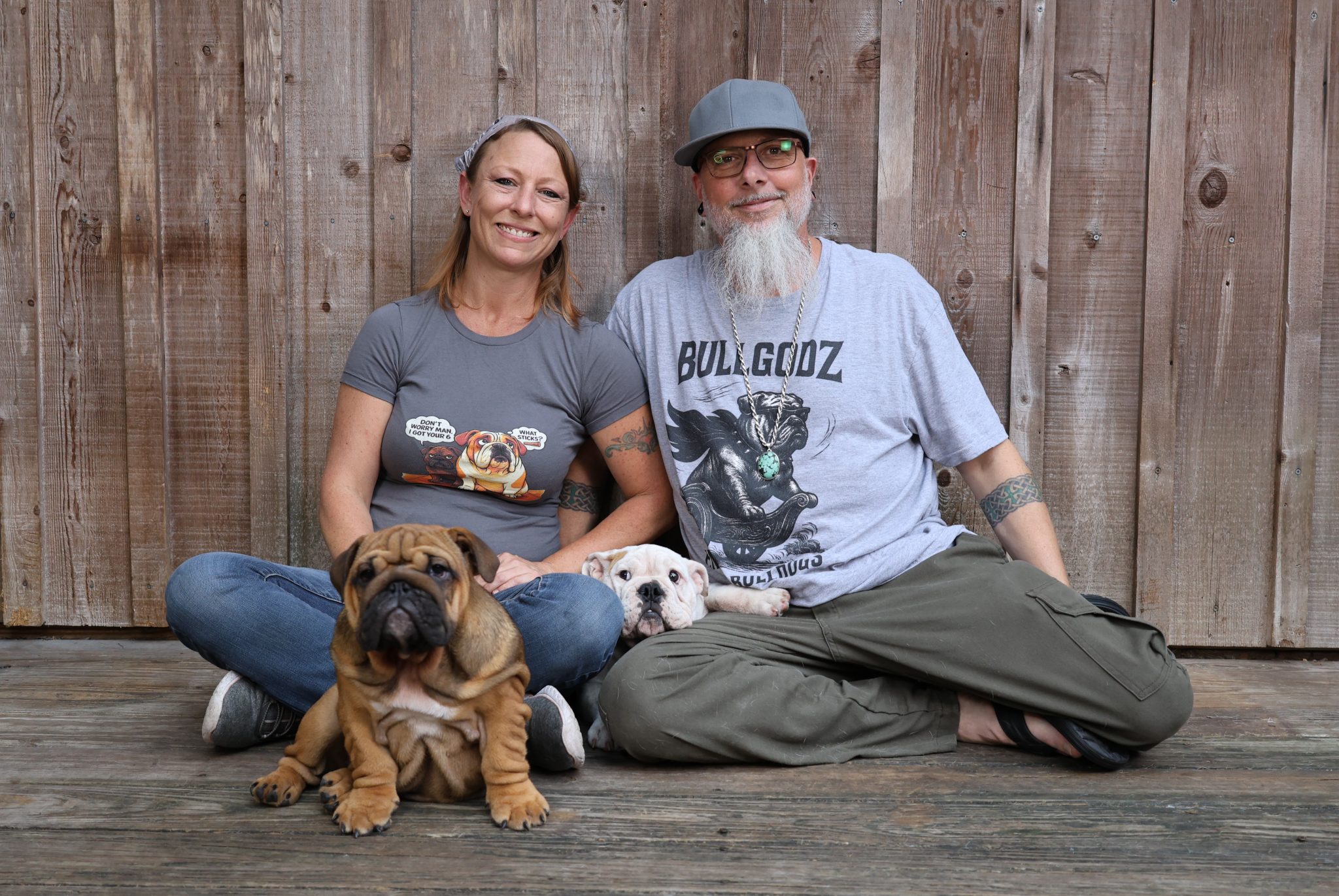 The Bullgodz HQ family sitting with their English Bulldogs, representing a lifestyle built around real dogs
